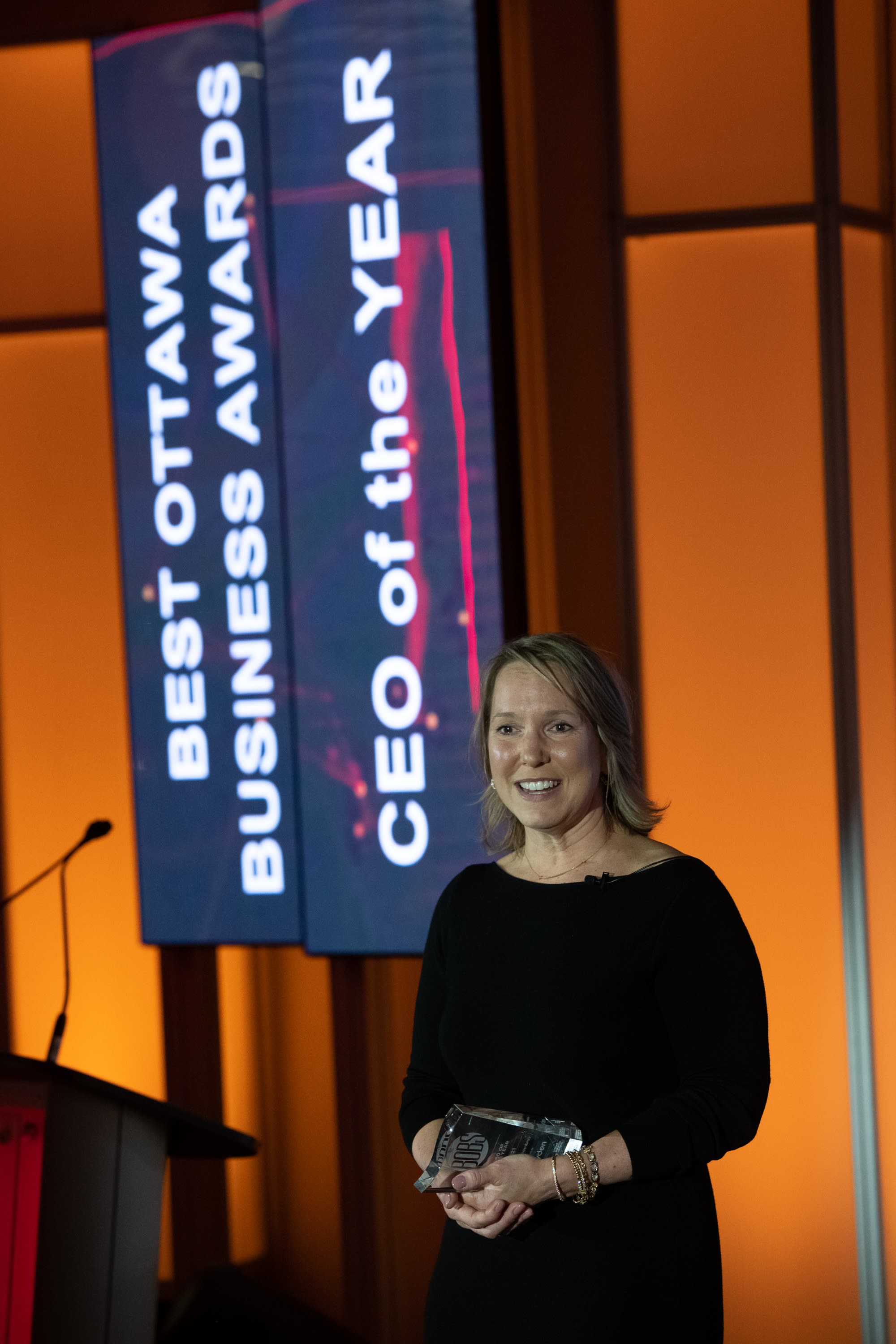 Kathryn Tremblay standing at a podium with an award