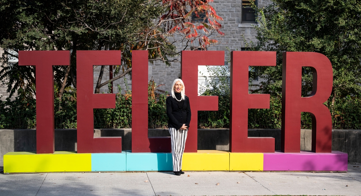Patricia Saputo in front of the Telfer sign at the Desmarais building