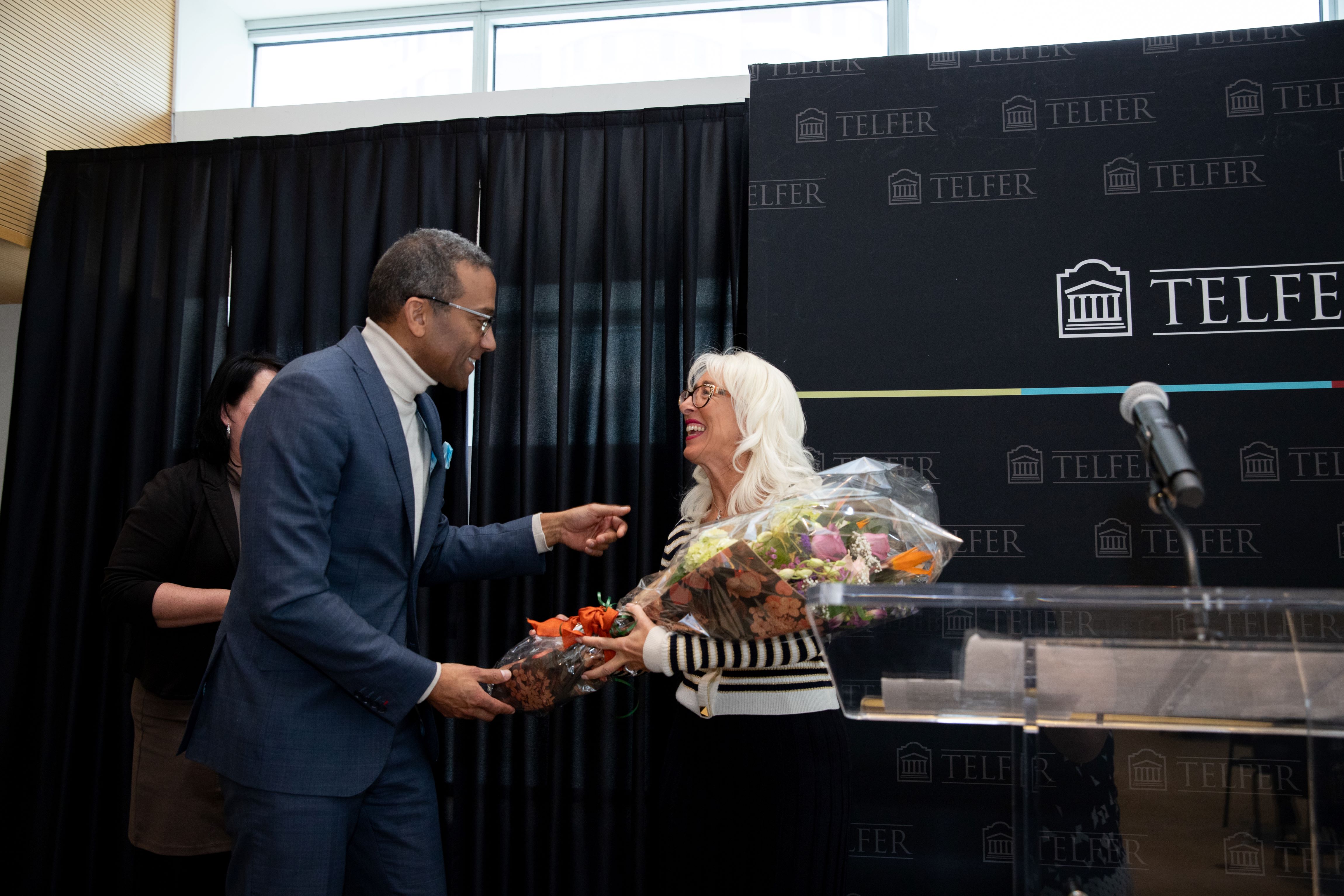 Patricia Saputo receives flowers from Dean Stéphane Brutus.