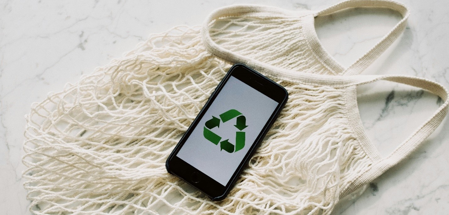 reusable shopping bag with phone on top showing a recycling symbol