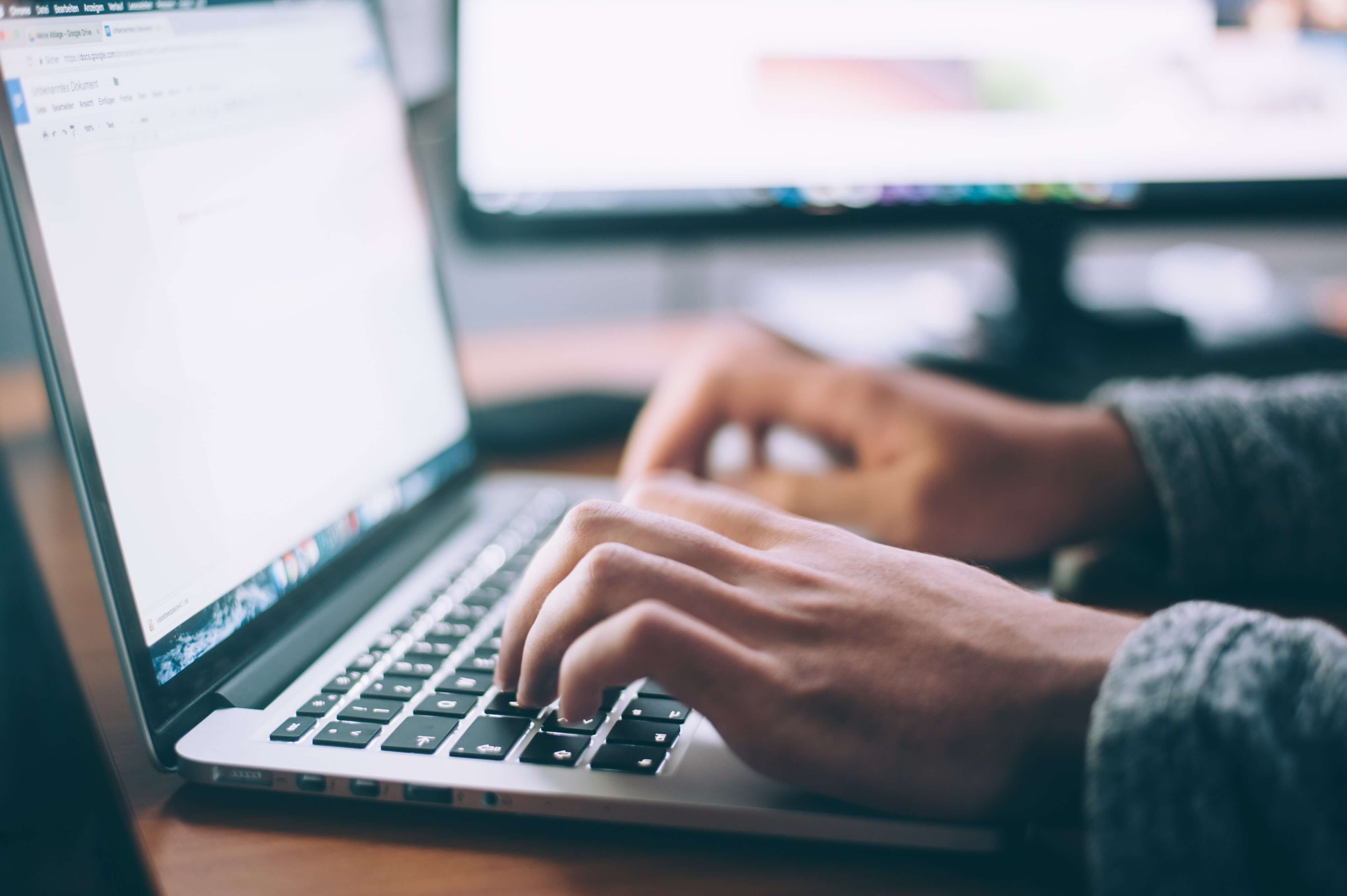 Student researching different BCom programs on a laptop