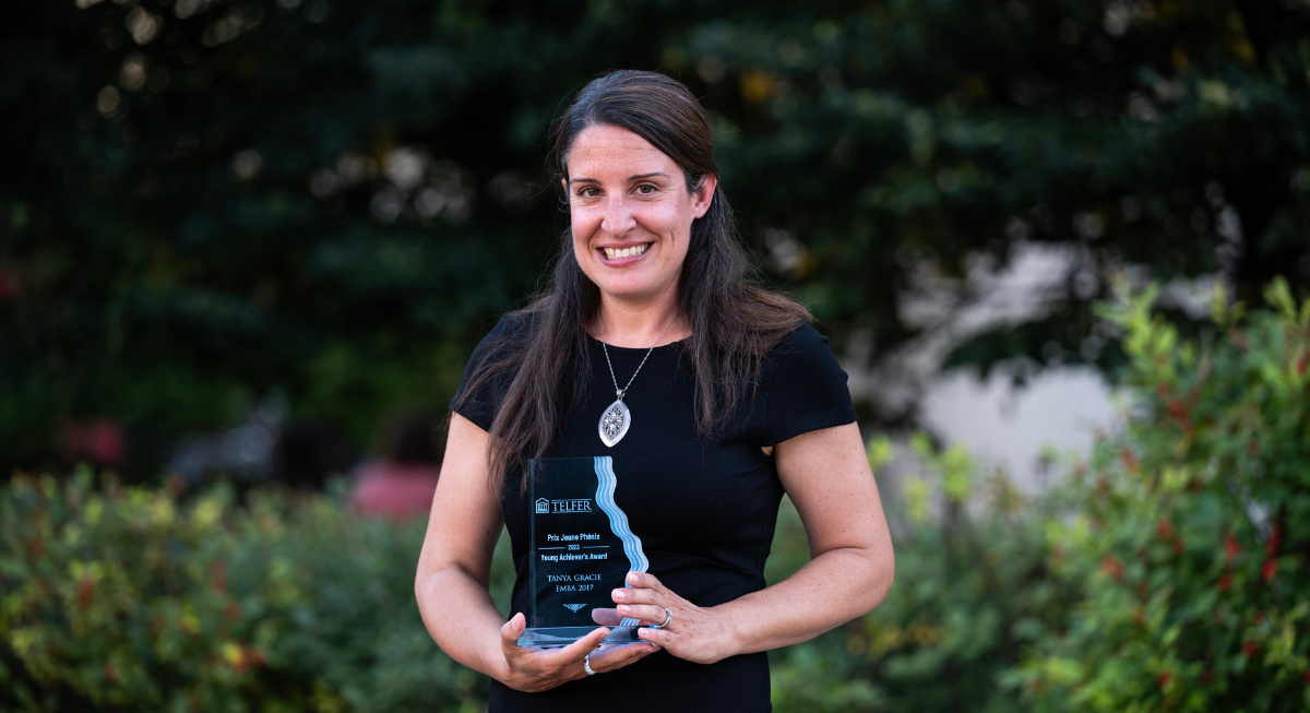 Tanya Gracie posing with the Young Achiever Award trophy