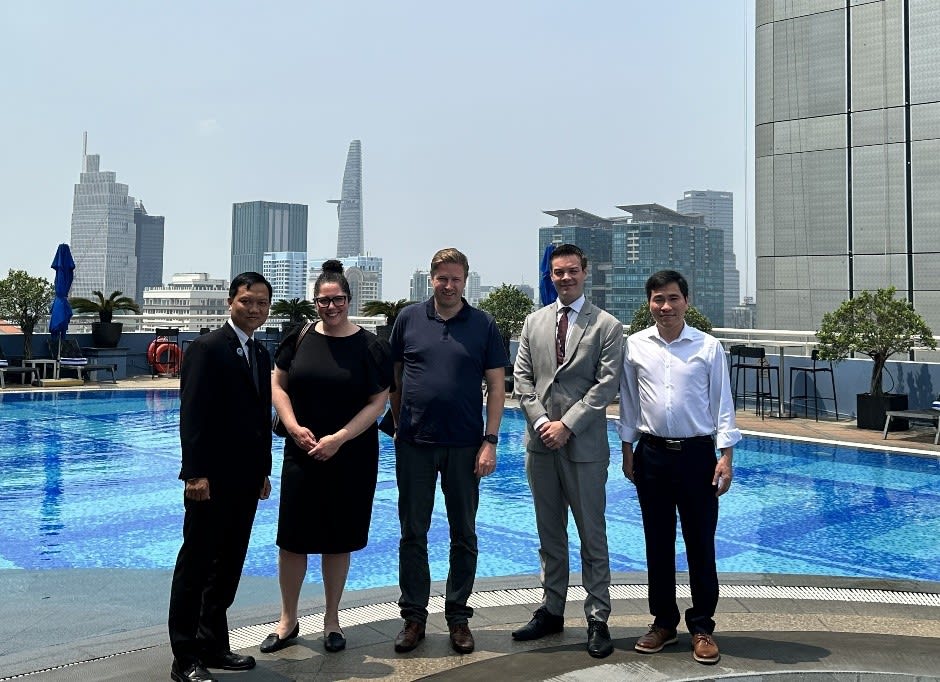 Telfer Executive MBA alumni Shayna Osterer, Malcolm Ranta and Giang Pham along with Gabriel Laflamme, Trade Commissioner, and Buu Khanh Nguyen, Director of Engineering, Sofitel Hotel standing outside the Sofitel Hotel in Ho Chi Minh City, Vietnam.