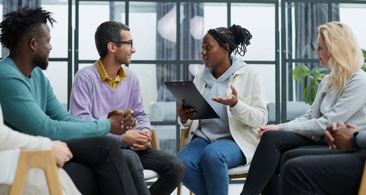 Three people listening to someone speak