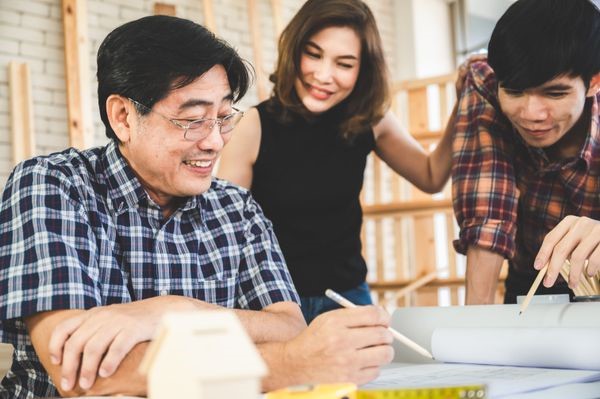 Three people looking at designs