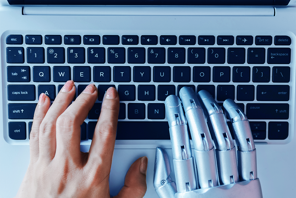 Top view of a white keyboard with black keys, one human left hand, one robot right hand, both typing.