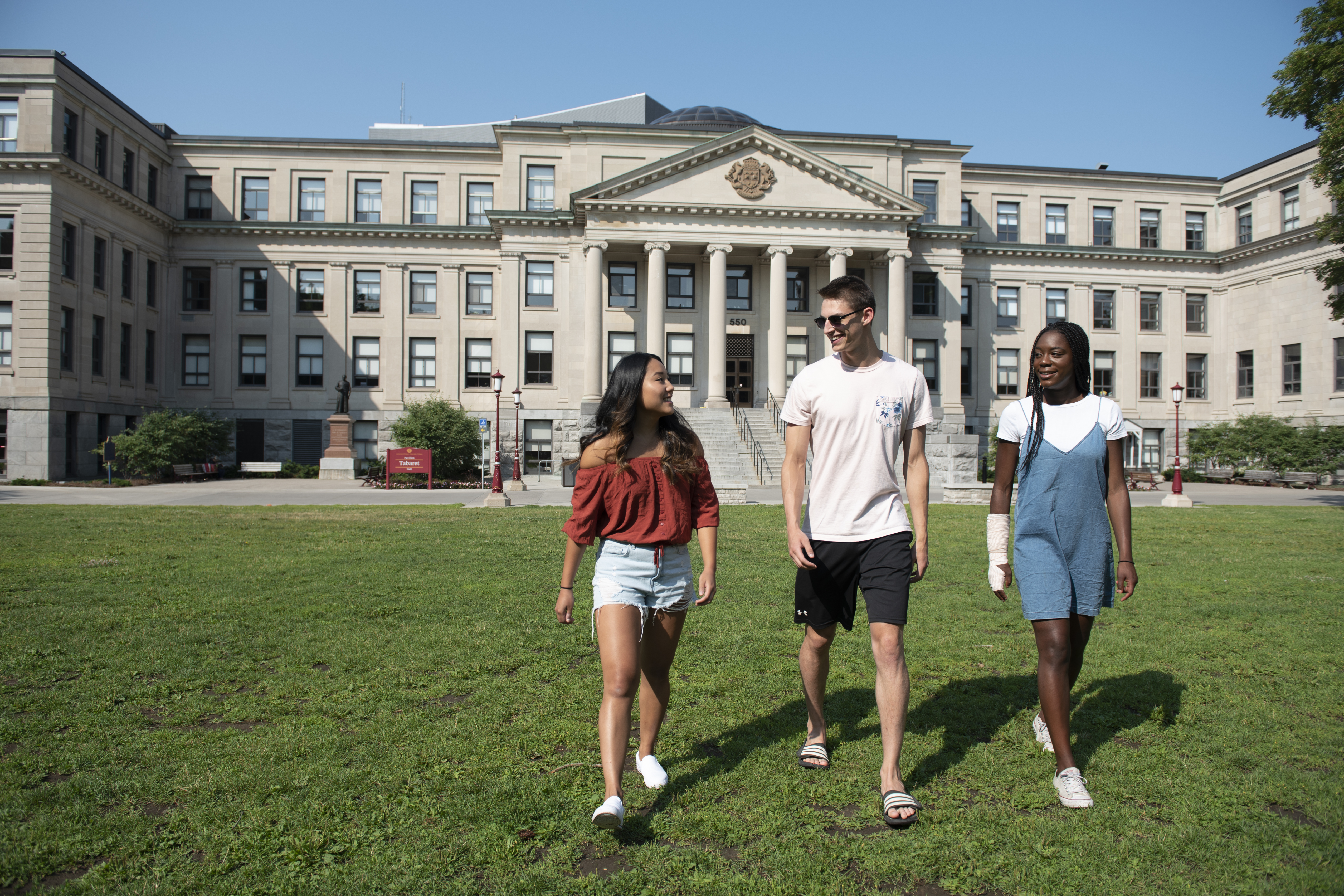 trois étudiants marchant et parlant à l'extérieur de Tabaret