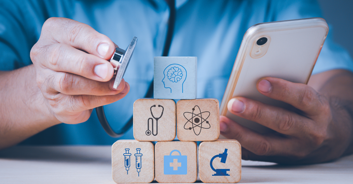 Two hands holding a phone and a stethoscope beside a stack of blocks with medical images