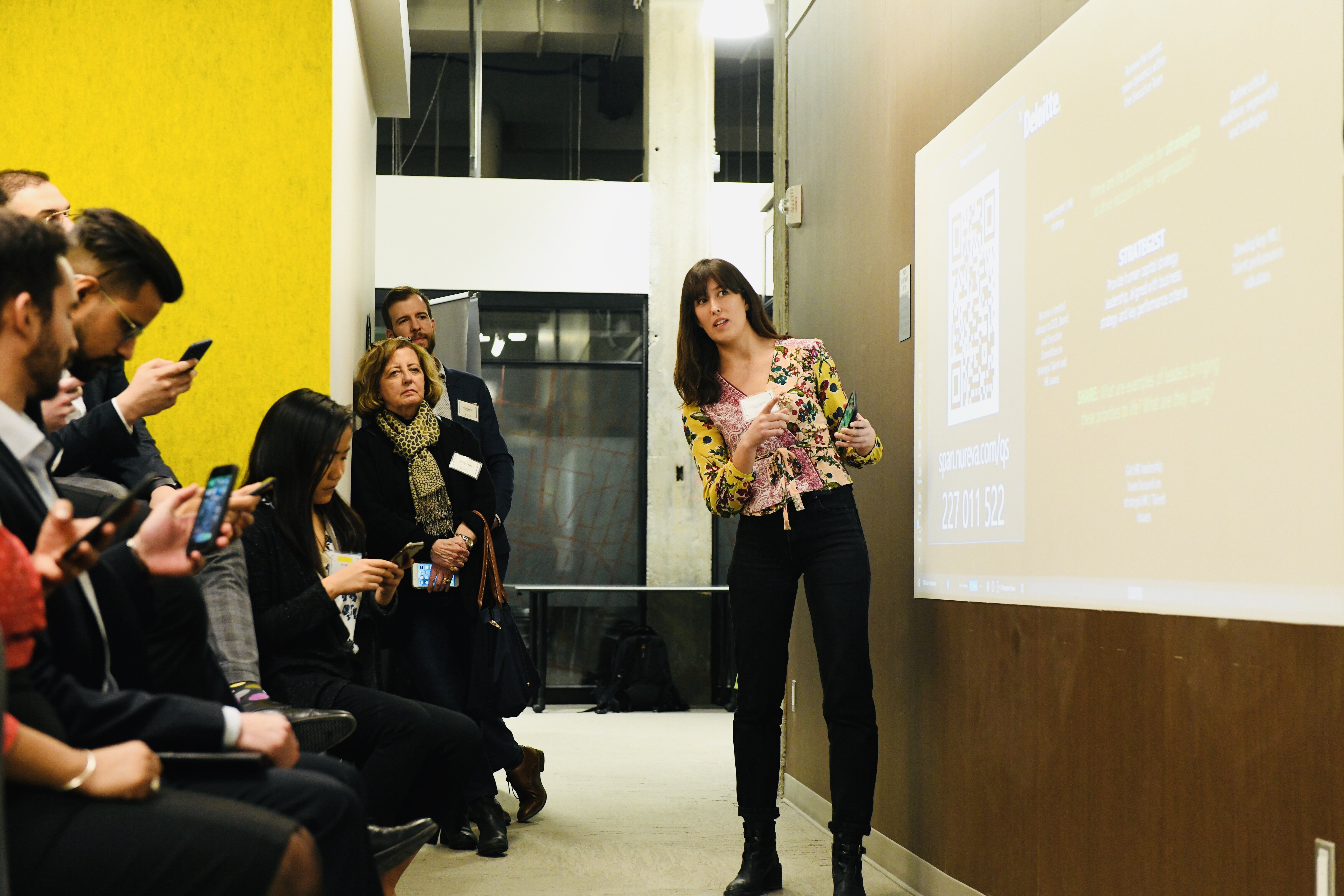 Woman presenting to an audience in front of a screen