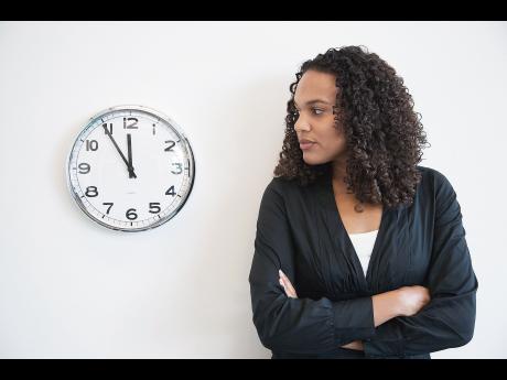 woman standing next to clock