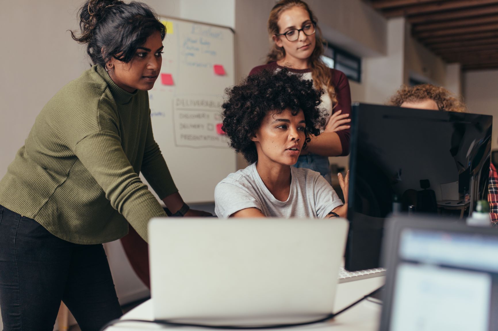 Young women working together in front of a computer screen